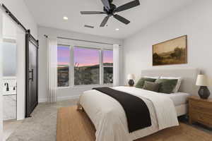 Bedroom featuring a barn door, light carpet, ceiling fan, and recessed lighting