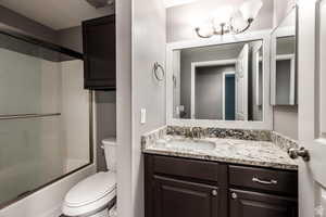 Full bath featuring vanity and shower / bath combination with glass door
