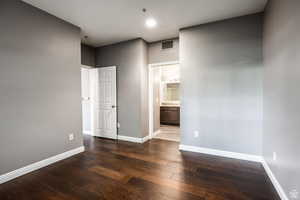 Unfurnished room with dark wood-type flooring and baseboards