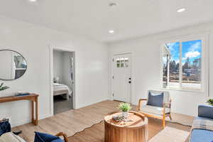 Living area with wood finished floors, recessed lighting, and a textured ceiling