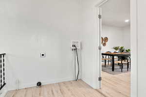 Laundry room with hookup for a washing machine, light wood-style flooring, and hookup for an electric dryer