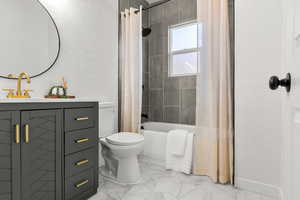 Full bathroom featuring a textured wall, shower / tub combo, and vanity