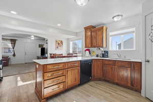 Kitchen with wood finish cabinets, a peninsula, arched walkway, and recessed lighting