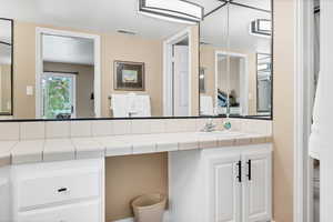 Ensuite bathroom with vanity and curtained shower