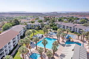 Drone / aerial view of a mountainous background and apartment complex / building