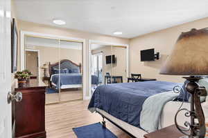 Bedroom with two closets and light wood-style floors