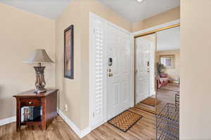 Foyer with light wood-style flooring and baseboards
