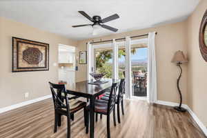 Dining room with light wood-style flooring, a ceiling fan, and a mountain view