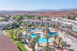 Aerial perspective of suburban area with a mountainous background and a pool