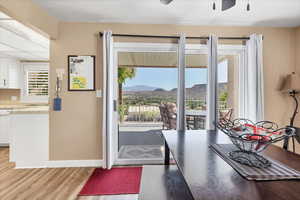 Dining space with a mountain view, light wood-style floors, and a ceiling fan