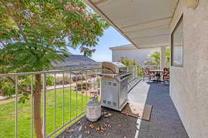 Patio / terrace with a lawn, grilling area, a mountain view, and outdoor dining area