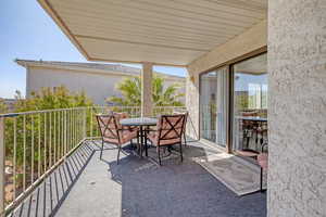 Balcony with outdoor dining area and a sunroom