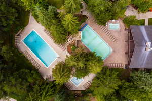 Drone / aerial view of a pool and a tree filled landscape