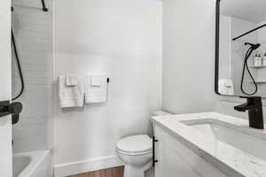 Full bathroom with shower / bathtub combination, vanity, and wood finished floors