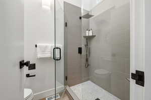Bathroom featuring a stall shower and toilet
