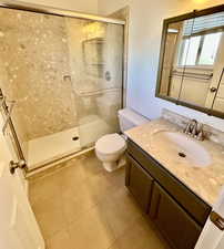Full bathroom featuring vanity, a stall shower, and light tile patterned floors