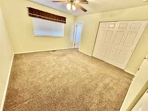 Unfurnished bedroom featuring a closet, carpet, and a ceiling fan