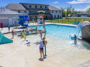 Community pool featuring a water slide and a patio area