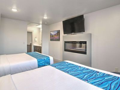 Bedroom featuring connected bathroom, a glass covered fireplace, and recessed lighting