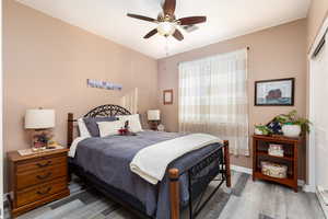Bedroom 2 featuring ceiling fan, engineered hardwood flooring, and a closet
