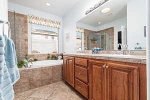 Full bath with double vanity, a stall shower, a garden tub, light tile patterned floors, and recessed lighting