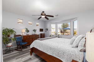 Primary bedroom featuring wood finished floors and a ceiling fan