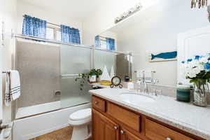 Hall bathroom featuring vanity, enclosed tub / shower combo, and light tile patterned floors