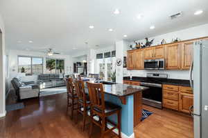 Kitchen with stainless steel appliances, granite countertops, hanging light fixtures, and plenty of natural light