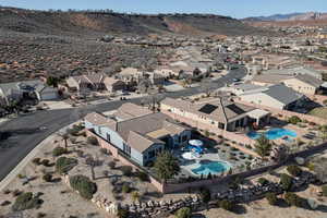 Aerial view of property and surrounding area featuring mountains and nearby suburban area