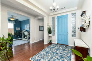 Entryway with hanging lights, dark wood-style flooring, and a ceiling fan