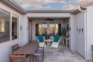 View of patio with outdoor dining area and ceiling fan