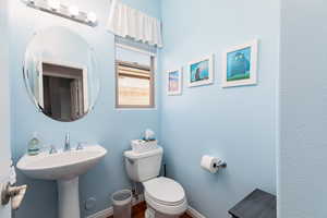 Half bathroom featuring toilet and baseboards