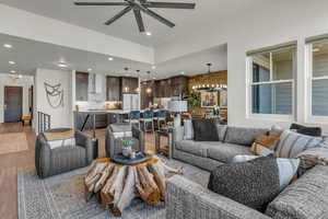Living room with wood finished floors, a ceiling fan, and a chandelier