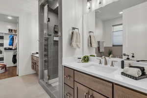 Bathroom featuring vanity, a spacious closet, recessed lighting, a shower stall, and light tile patterned floors