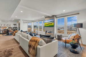 Living area featuring a glass covered fireplace, light wood-style flooring, and recessed lighting