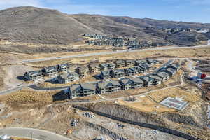 Aerial view of property and surrounding area featuring nearby suburban area and a mountainous background