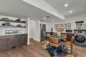 Dining area with washer / dryer, light wood-style flooring, and recessed lighting