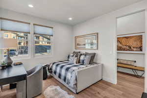 Bedroom featuring light wood finished floors, recessed lighting, and an office area