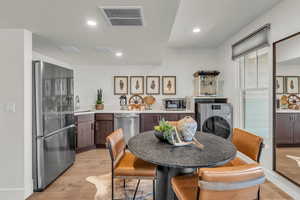 Kitchen with stainless steel appliances, light wood-style floors, recessed lighting, and dark wood finish cabinets