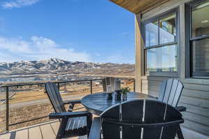 Balcony featuring outdoor dining space and a mountain view