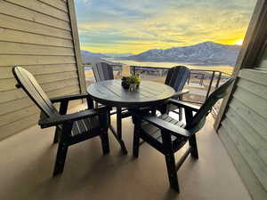 Balcony at dusk featuring outdoor dining area and a mountain view