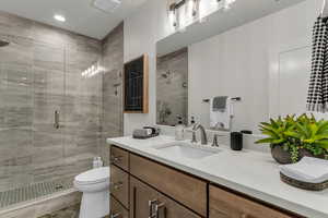 Full bathroom featuring vanity, a shower stall, and recessed lighting