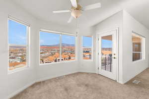 Unfurnished sunroom with carpet flooring and a mountain view
