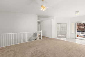 Unfurnished room featuring light colored carpet and a ceiling fan