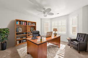 Office space featuring light colored carpet and a ceiling fan