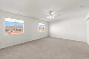 Spare room with carpet floors, a mountain view, and a ceiling fan