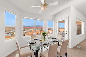 Dining area with light carpet, a mountain view, and a ceiling fan