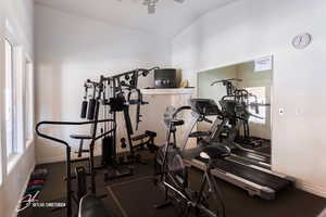 Gym with lofted ceiling and ceiling fan