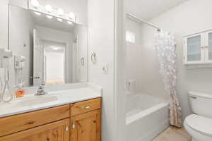 Bathroom featuring shower / tub combo with curtain and vanity
