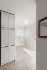 Unfurnished bedroom with light tile patterned flooring and baseboards